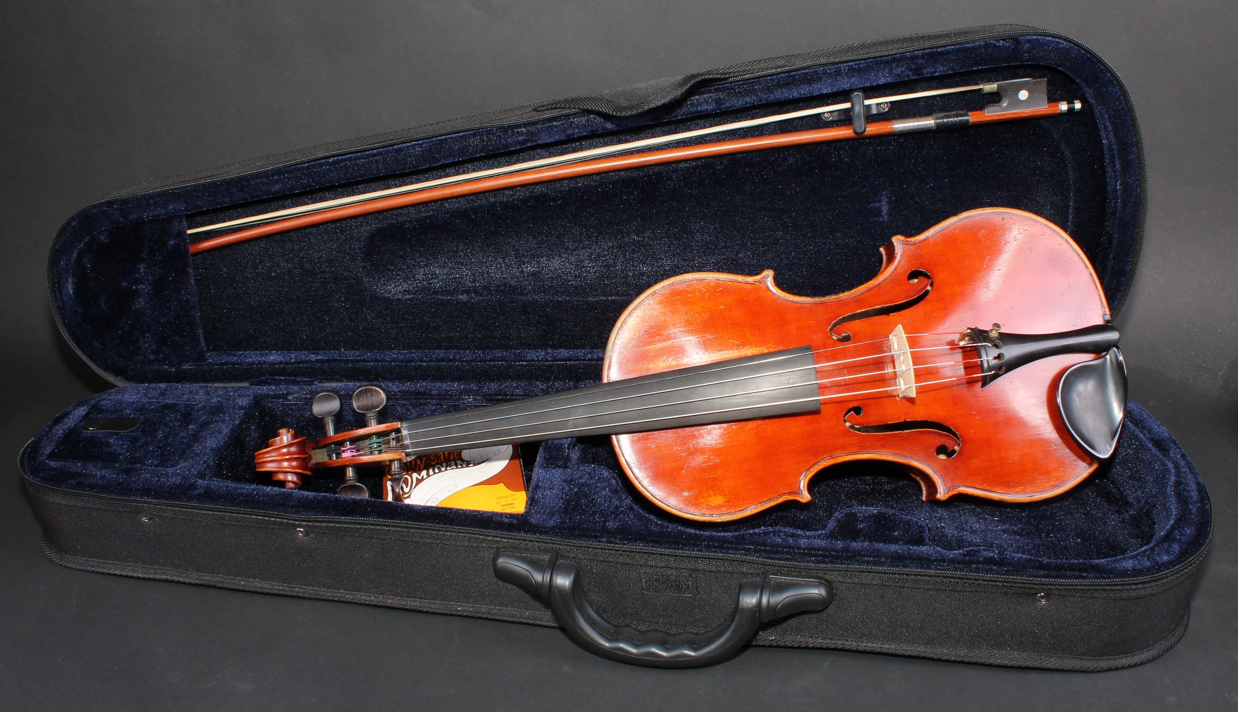 A violin, two piece back, paper label, made by John Wilkinson, London 1919, paper label, the two-piece back 35.5cm long excluding button, rosewood tuning pegs, outlined throughout with purfling, 60cm long overall, the silver wire bound bow 74cm long, modern carry case